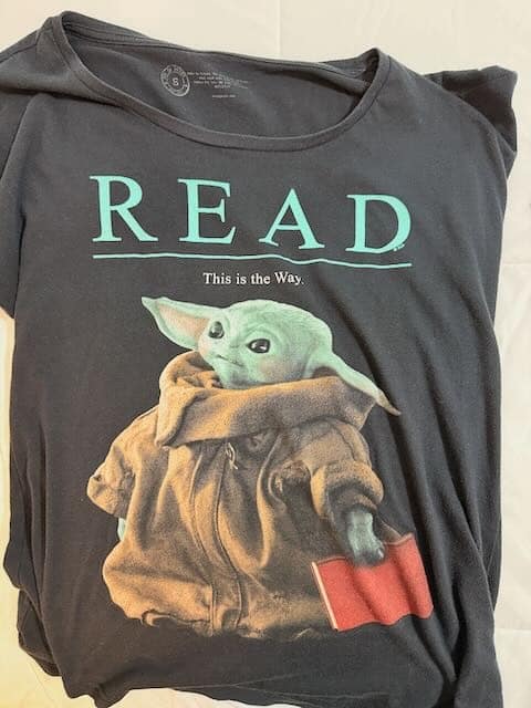 Grogu Read T-Shirt Green text says Read. Underneath, Grogu from the Mandalorian holds a red book in his hand.