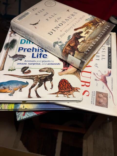 A stack of children's books about dinosaurs.
