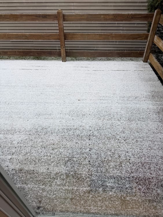 A light covering of snow on a wooden deck.