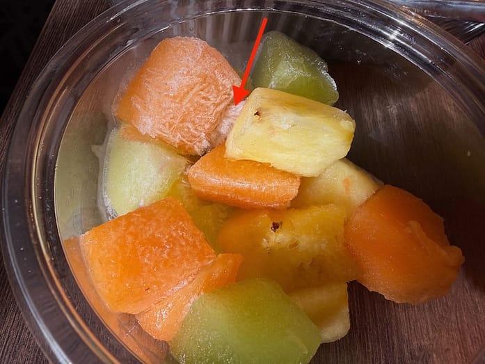 Frozen Fruit A photo of cubes of orange cantalope, pale green melon, and yellow pineapple. There are ice crystals connecting the cubes.